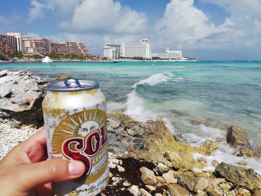 Tomando cerveza Sol en una playa de Cancún.